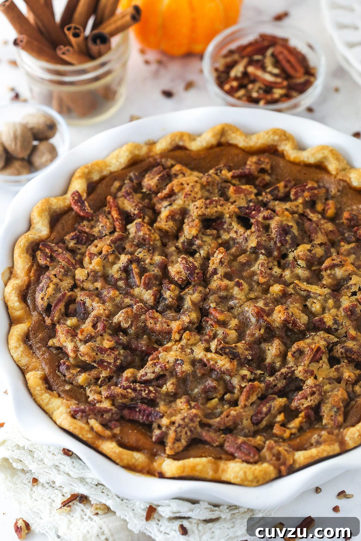 Caramelized Pecan Pumpkin Pie 11 A whole pecan praline pumpkin pie resting in a pie dish, with a perfect golden crust and glistening topping.