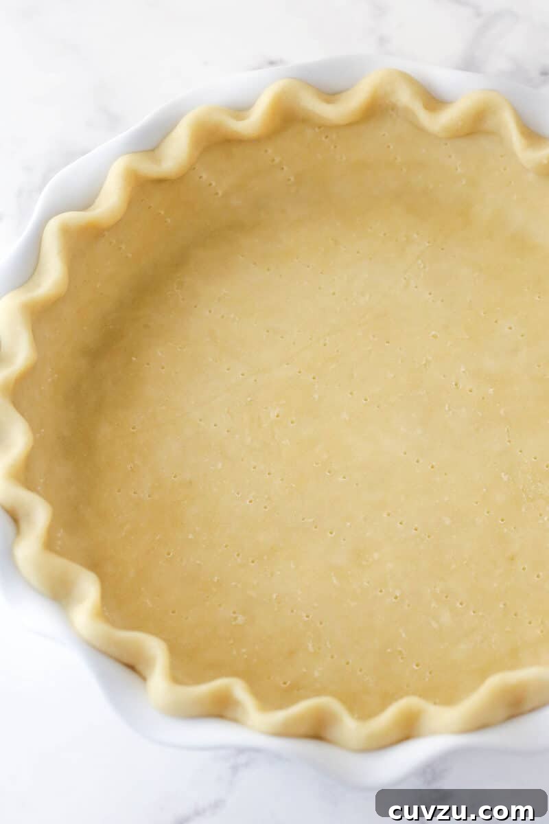 Caramelized Pecan Pumpkin Pie 5 Unbaked pie crust expertly shaped into a pie dish, ready for blind baking.