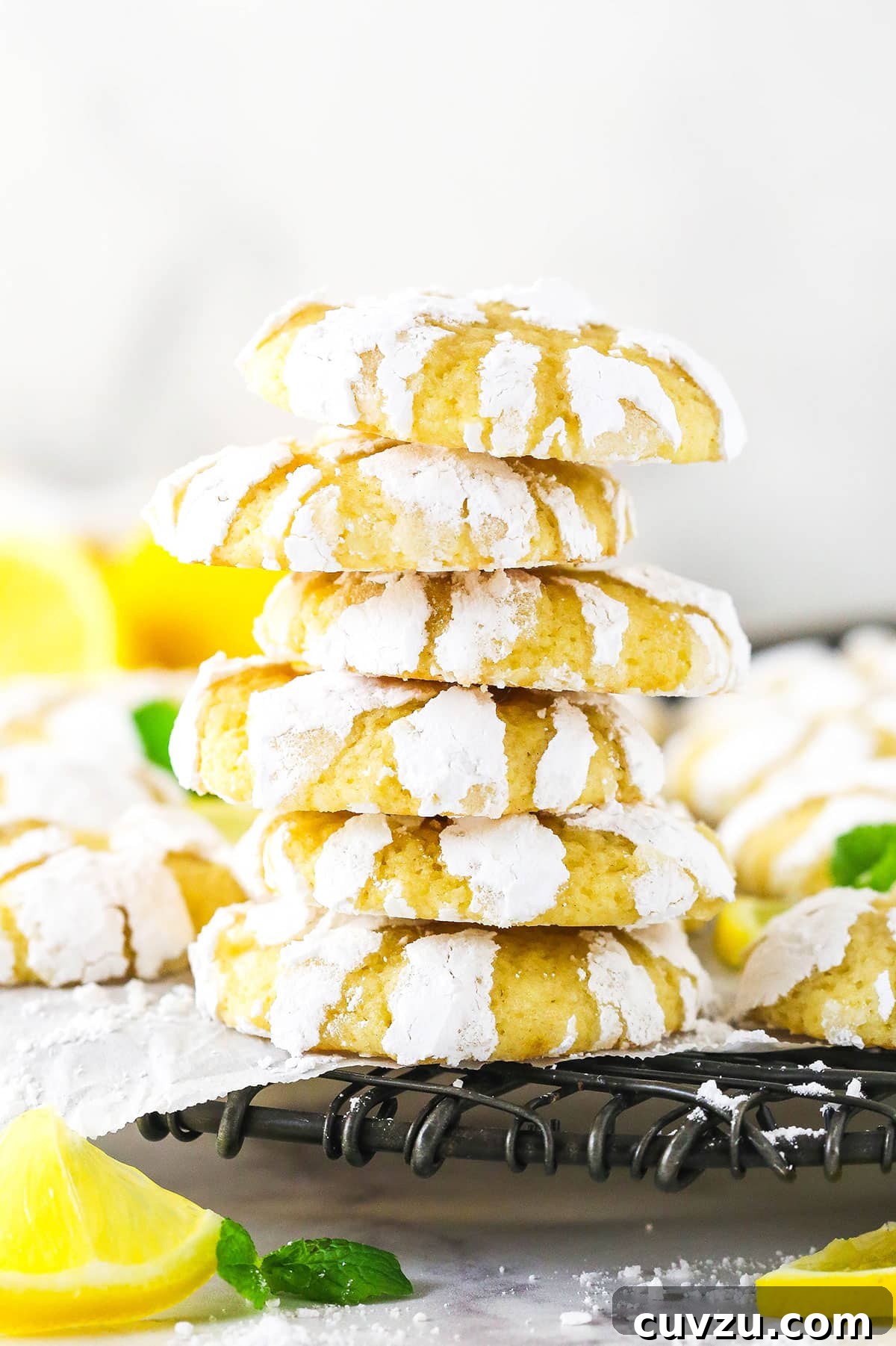 Indulge in these bright and beautiful Lemon Crinkle Cookies, bursting with fresh lemon zest and juice, and elegantly finished with a charming crackled powdered sugar coating. A perfectly stacked tower of five lemon crinkle cookies, highlighting their unique powdered sugar coating and inviting texture.