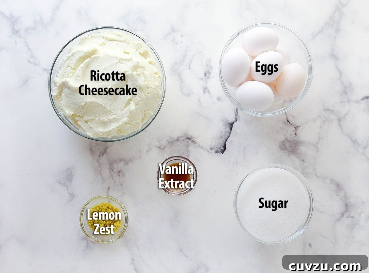 Ricotta Cheesecake Ingredients Laid Out An overhead shot showcasing the five simple ingredients required to make a ricotta cheesecake: a bowl of strained ricotta, sugar, vanilla extract, lemon zest, and eggs.