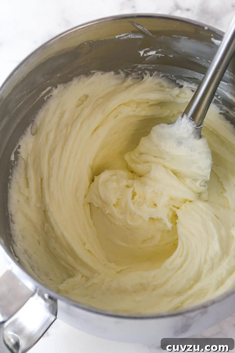 Tropical Delight Cake 12 Smooth, creamy coconut buttercream frosting in a large mixing bowl.