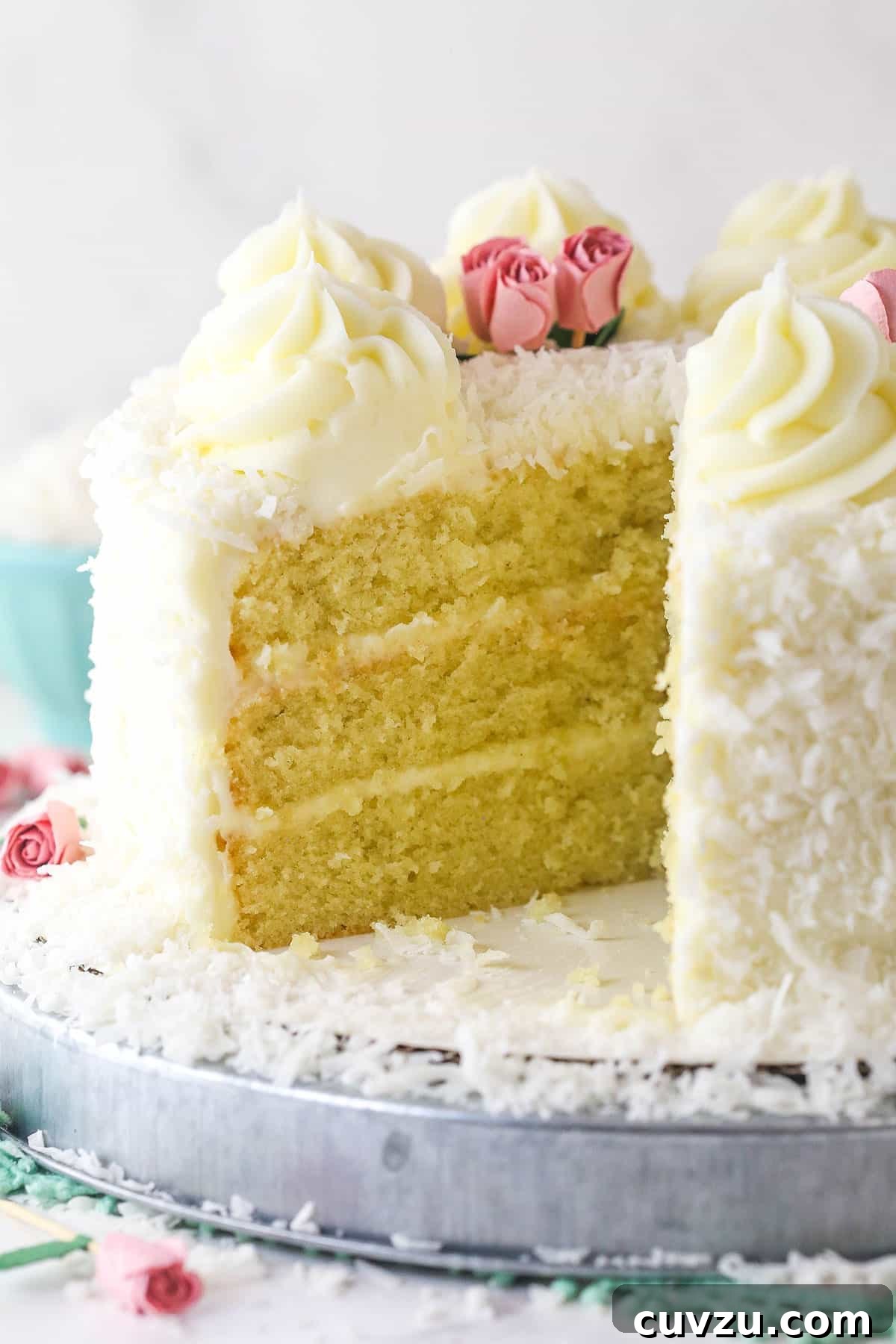 Tropical Delight Cake 17 A beautifully decorated coconut cake with one slice removed, revealing its moist, layered interior.