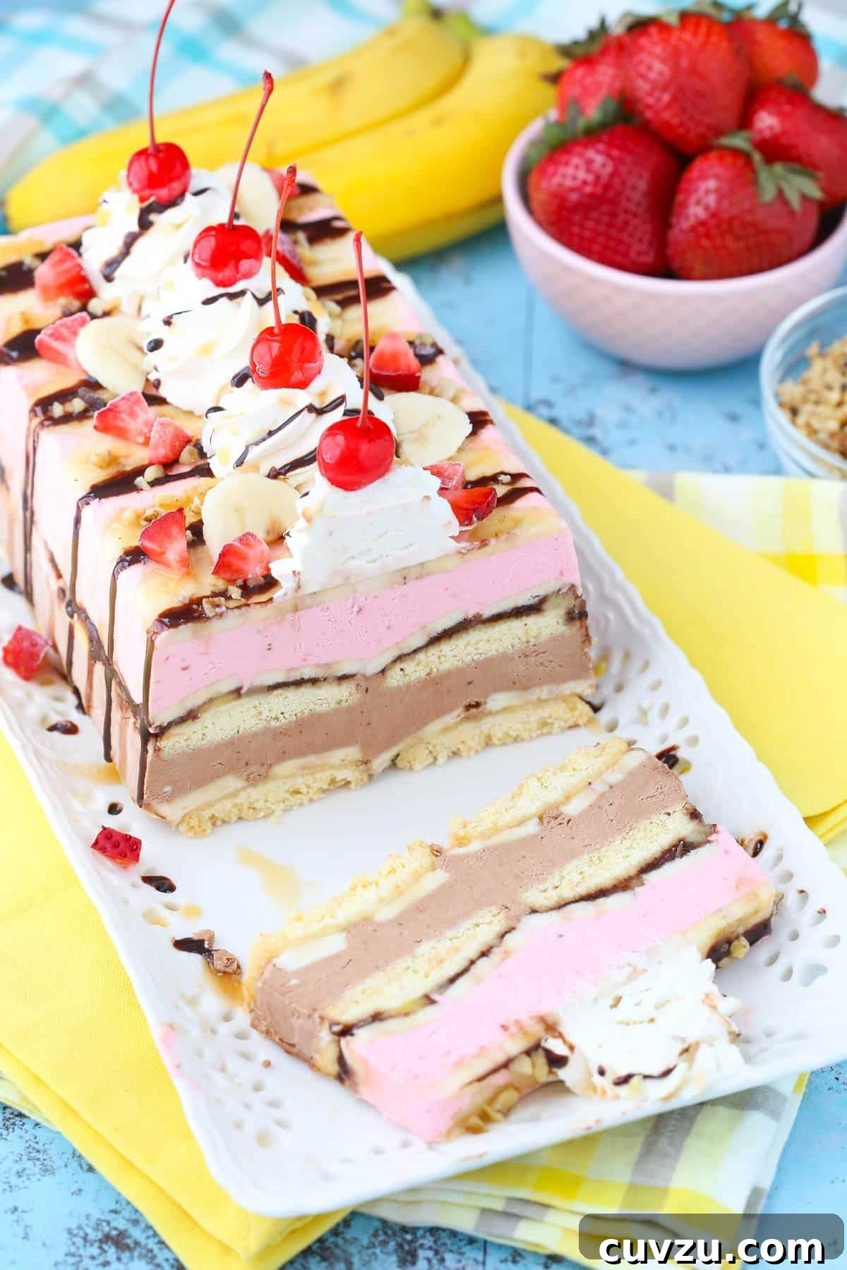 Frozen Banana Split Loaf 7 The banana split ice cream cake loaf on a white tray with one slice neatly removed, showcasing its inner beauty and irresistible appeal.