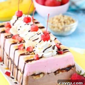 Side view of a banana split ice cream cake loaf on a white tray.