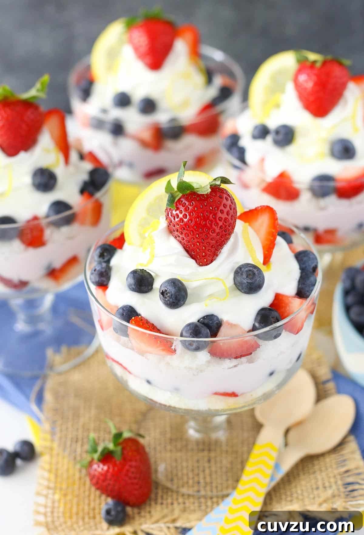 Tangy Berry Bliss Layers 7 A stunning side view of four individual lemon berry yogurt trifles arranged neatly, highlighting their uniform layers and festive appearance.