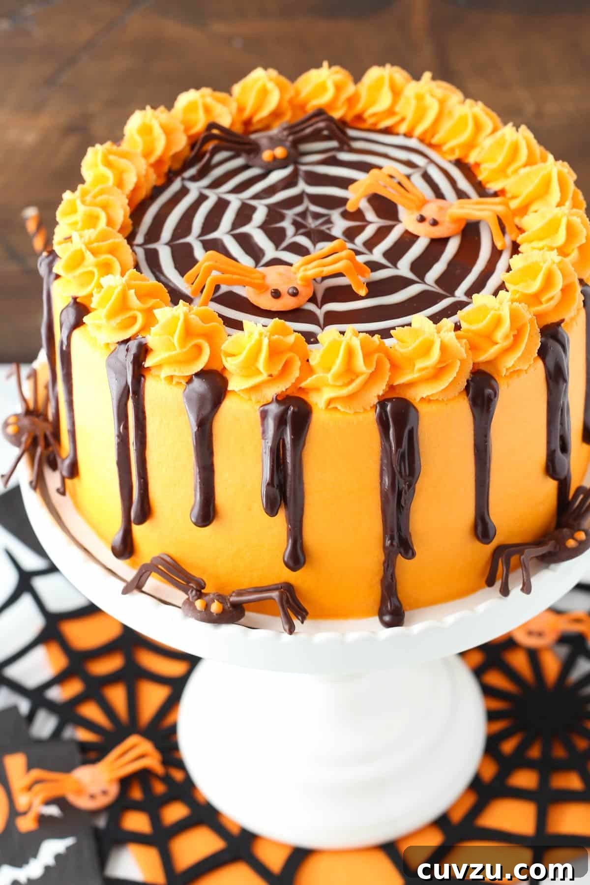 Haunted Web Chocolate Cake with Silky Vanilla Glaze 2 A spiderweb chocolate cake on a white cake stand, perfectly decorated for Halloween.