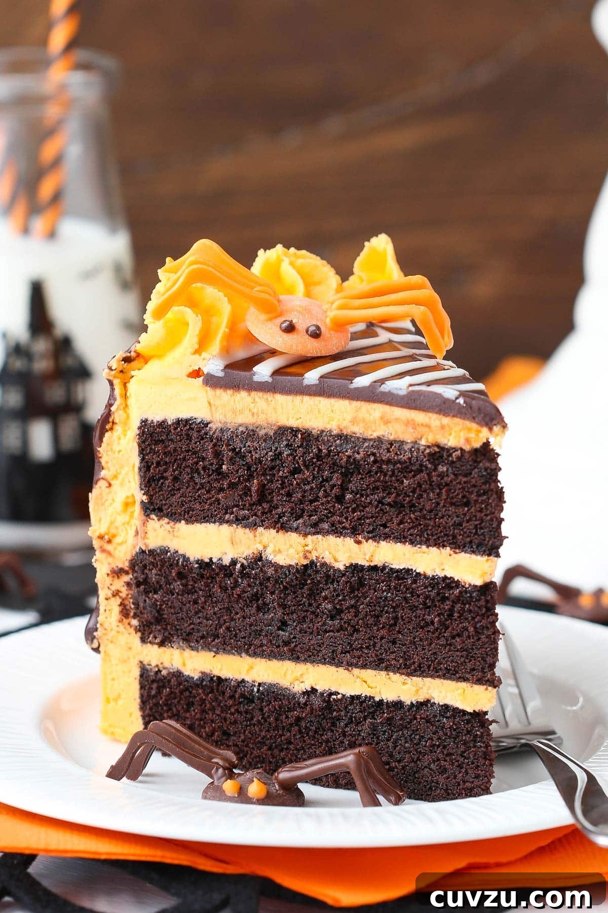 Haunted Web Chocolate Cake with Silky Vanilla Glaze 3 Close-up of a slice of spiderweb chocolate cake on a white plate, showing the moist layers and intricate web design.