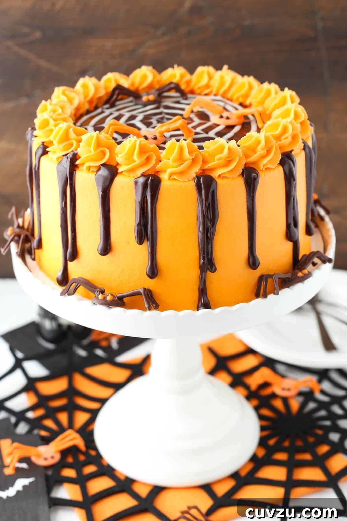 Haunted Web Chocolate Cake with Silky Vanilla Glaze 8 A complete spiderweb chocolate cake on a white cake stand, ready for serving.