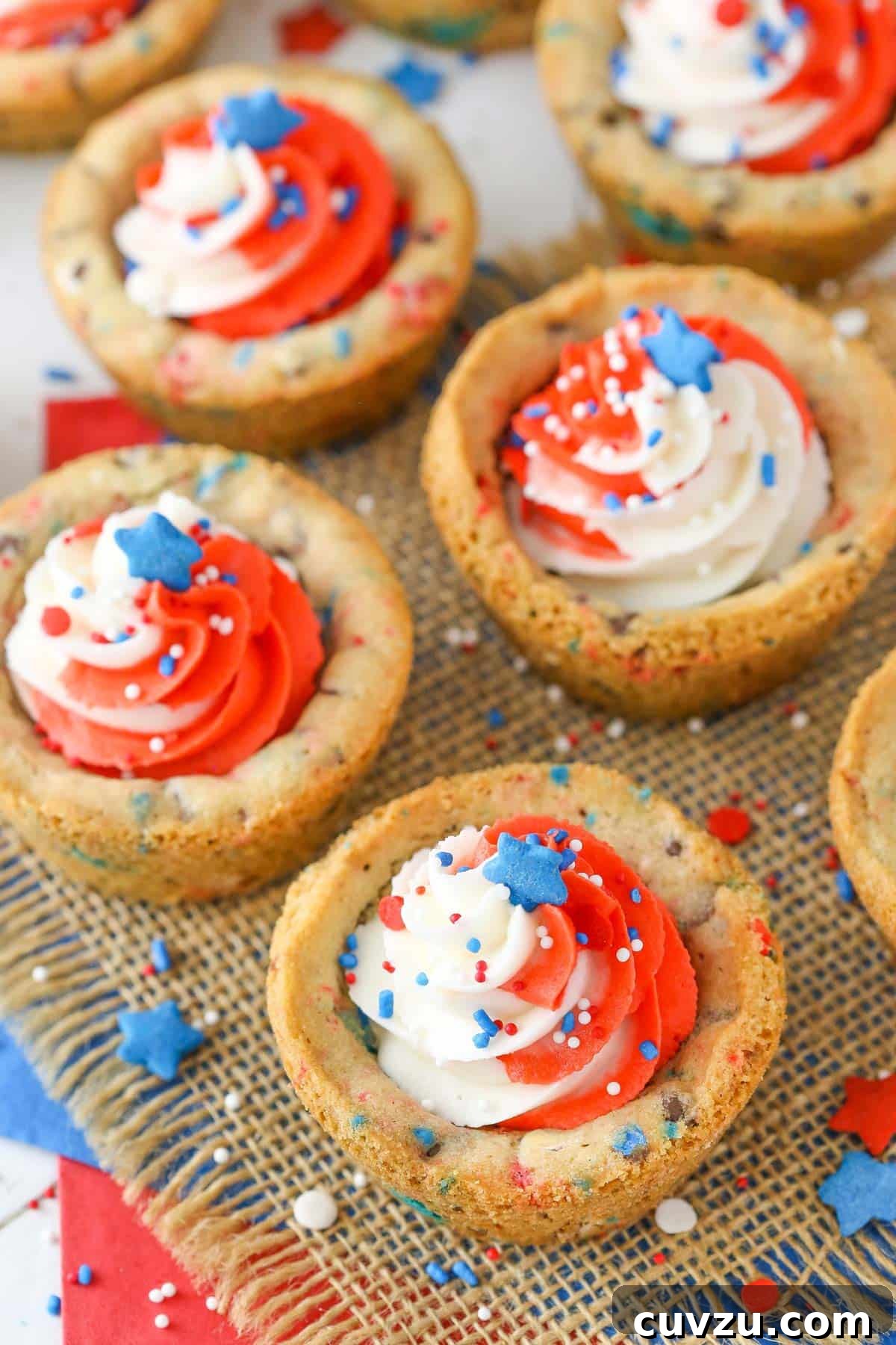 Stars and Stripes Chocolate Chip Cookie Cups 3 Top-down view of several patriotic chocolate chip cookie cups arranged on layered red, white, and blue napkins, showcasing their festive appeal.