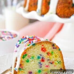 A slice of funfetti bundt cake on a white plate.