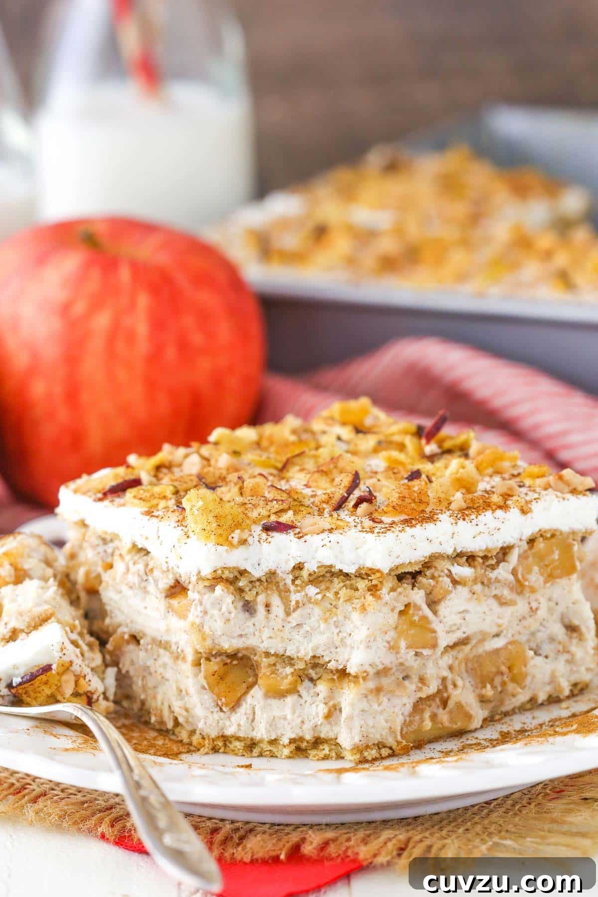 Spiced Apple No-Bake Delight 4 A slice of Cinnamon Apple Icebox Cake on a white plate with a bite taken out, showing the soft layers.