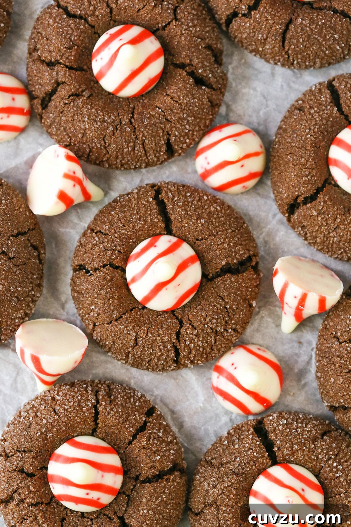 Beautifully displayed Peppermint Chocolate Thumbprint Cookies, ideal for holiday gatherings. An overhead view of Peppermint Chocolate Thumbprint Cookies artfully arranged on parchment paper, showcasing their appealing presentation.