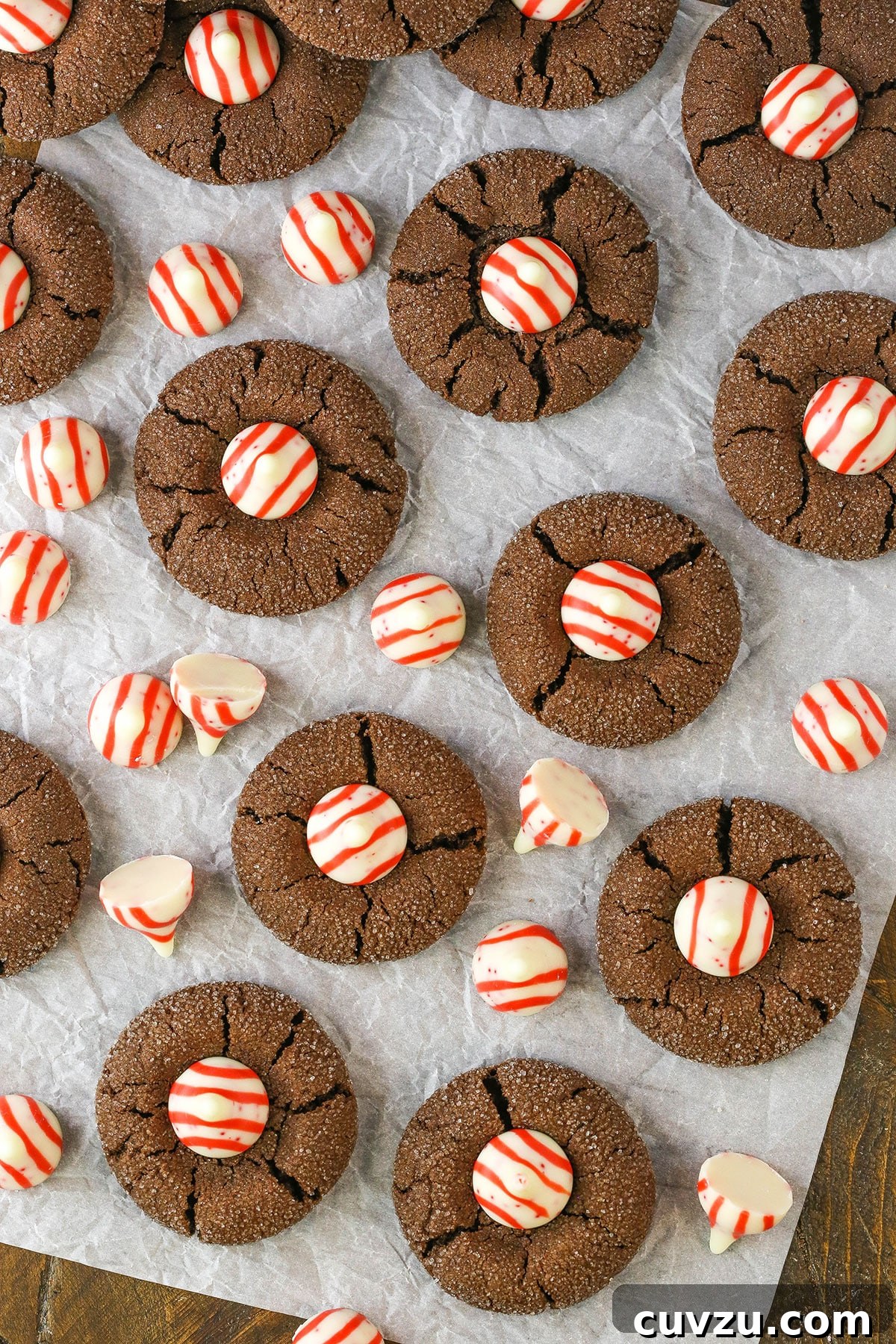 A charming display of Peppermint Chocolate Thumbprint Cookies on a wooden surface. An artistic overhead view of Peppermint Chocolate Thumbprint Cookies arranged on parchment paper on a rustic wooden table, ready to be enjoyed.