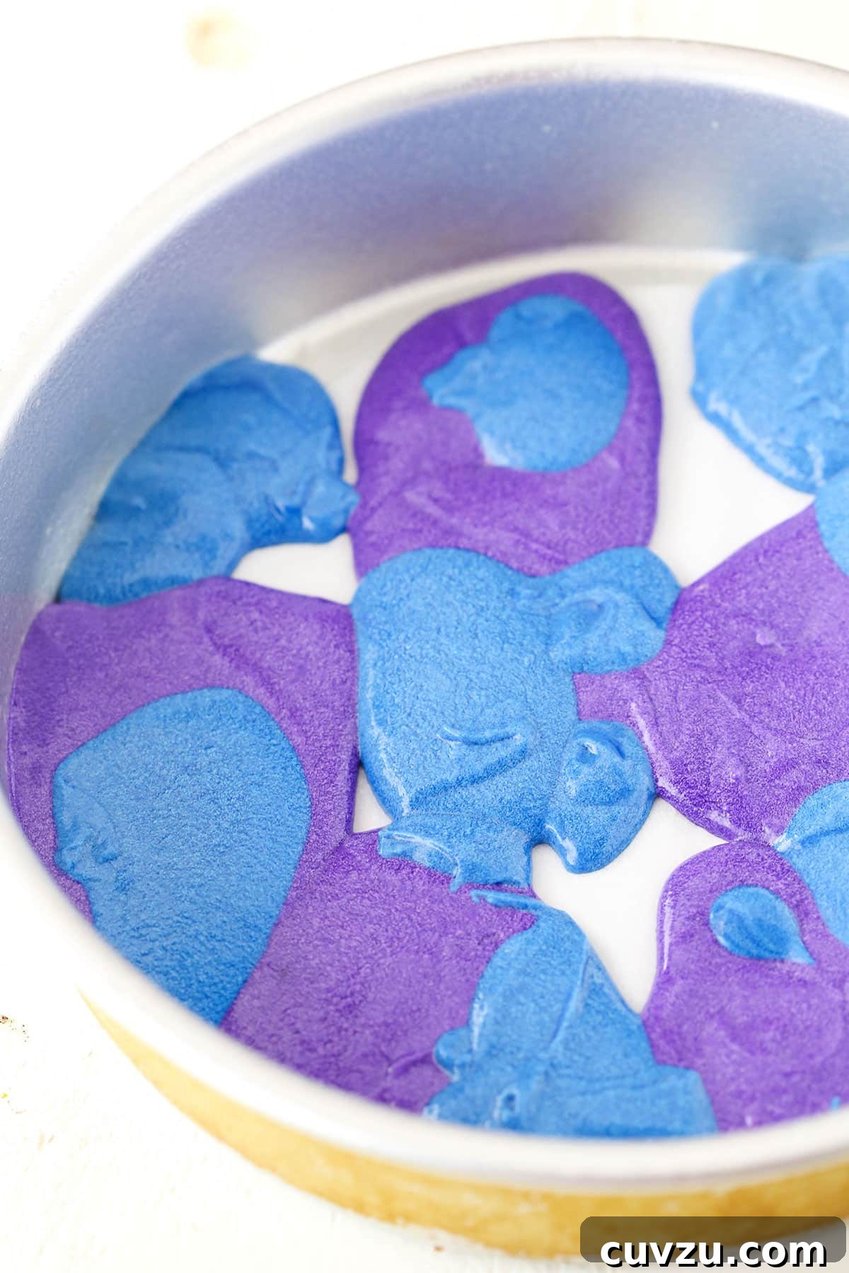 Kaleidoscope Cake 6 A step-by-step image illustrating the process of layering different colored cake batters into a pan to achieve the distinctive rainbow swirl effect.