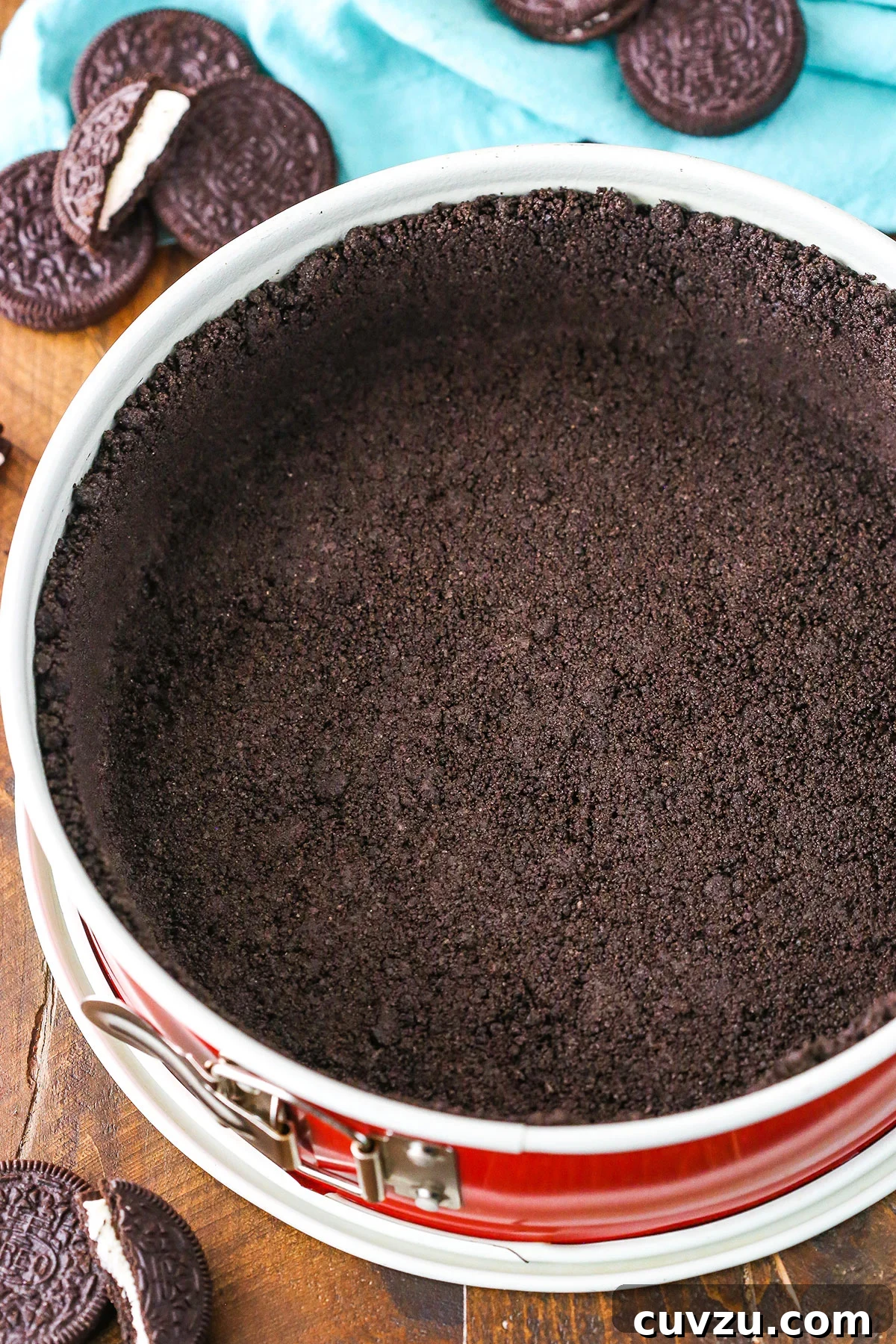 Effortless Oreo Pie Crust 3 Oreo Cookie Crust in a red springform pan on a wooden table