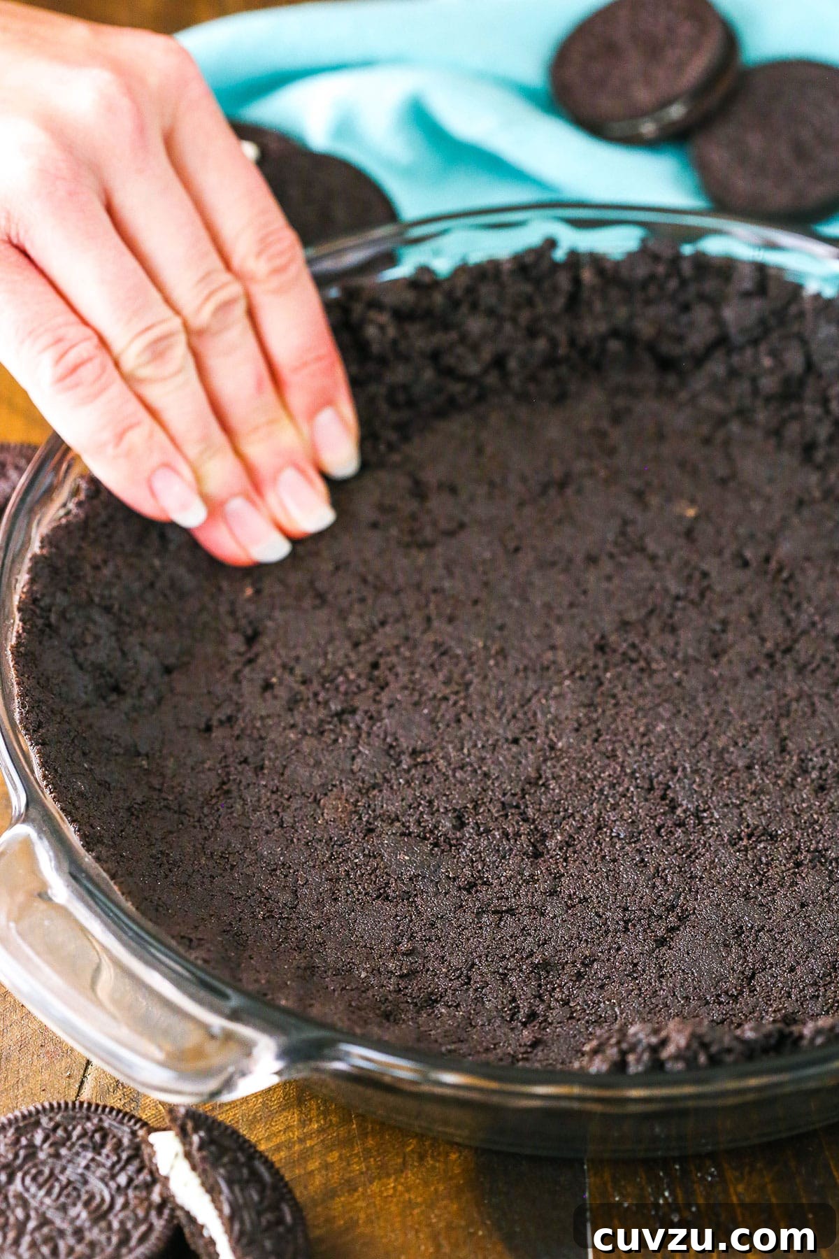Effortless Oreo Pie Crust 7 Oreo Cookie Crust being pressed into a clear glass pan