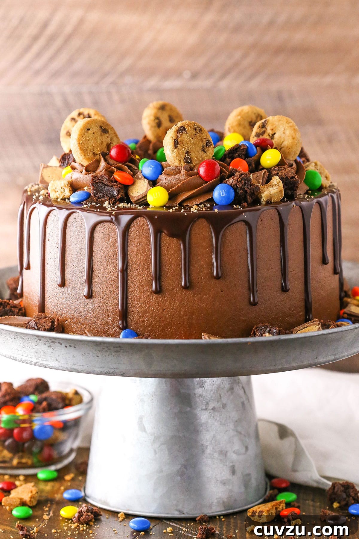Candy Burst Chocolate Confection 4 Side view of a complete Chocolate Piñata Cake on a gray cake stand.