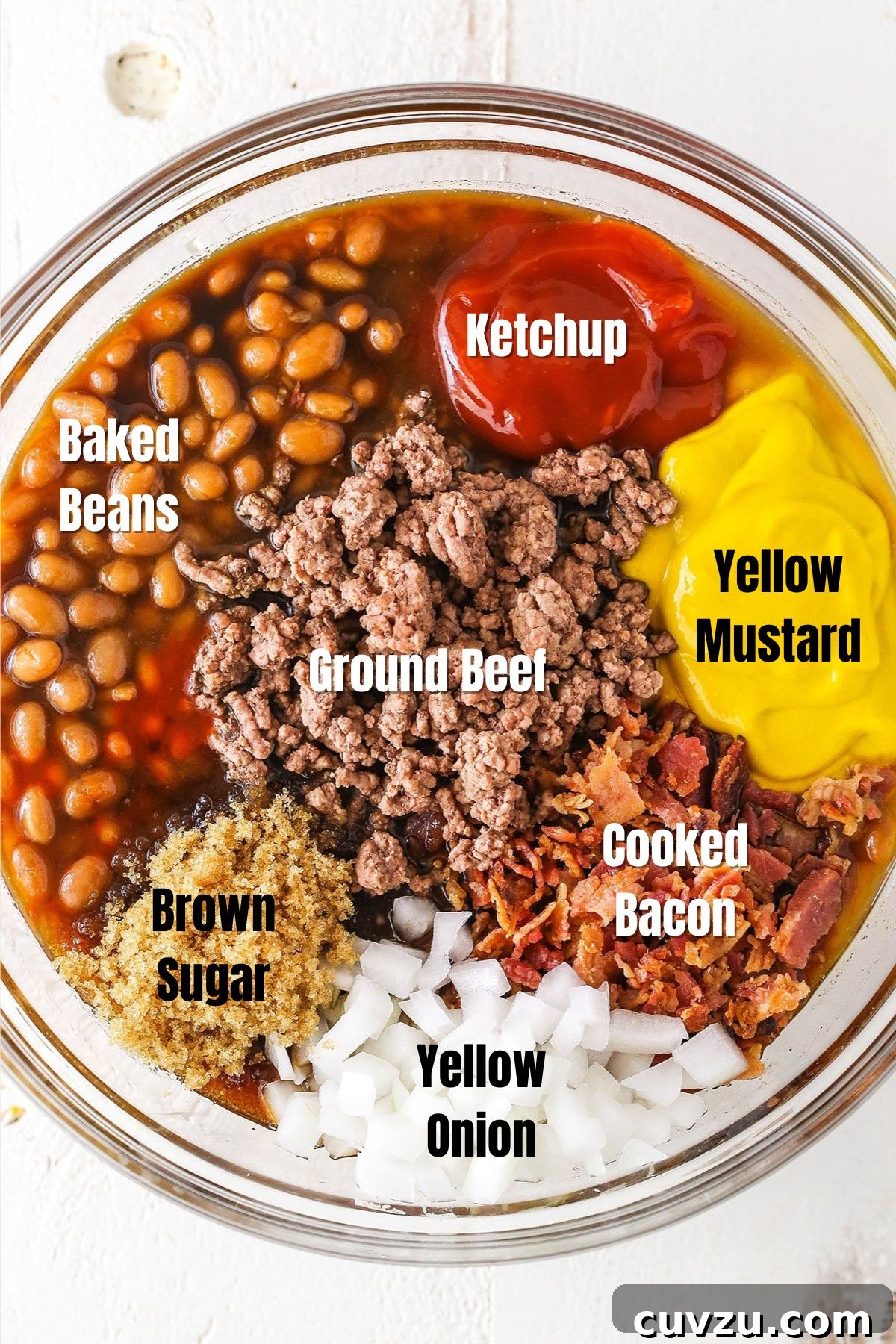 Mom's Legendary Baked Beans 3 A vibrant collection of ingredients for Mom’s Amazing Baked Beans, including canned beans, ketchup, mustard, brown sugar, onions, bacon, and ground beef, laid out on a clean surface.