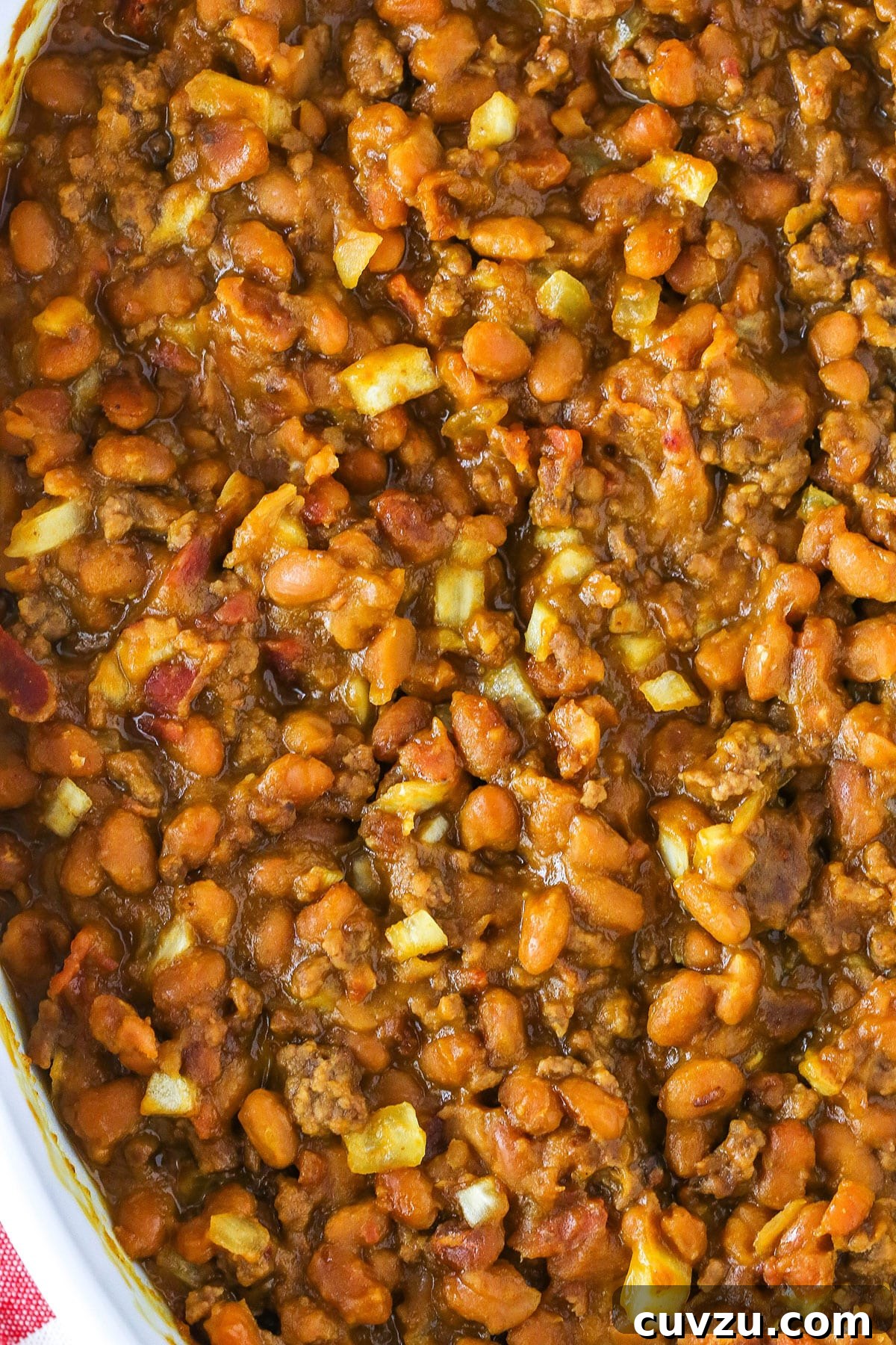 Mom's Legendary Baked Beans 6 A tantalizing overhead view of Mom's Amazing Baked Beans served in a white casserole dish, garnished and ready for sharing at a family meal or BBQ.