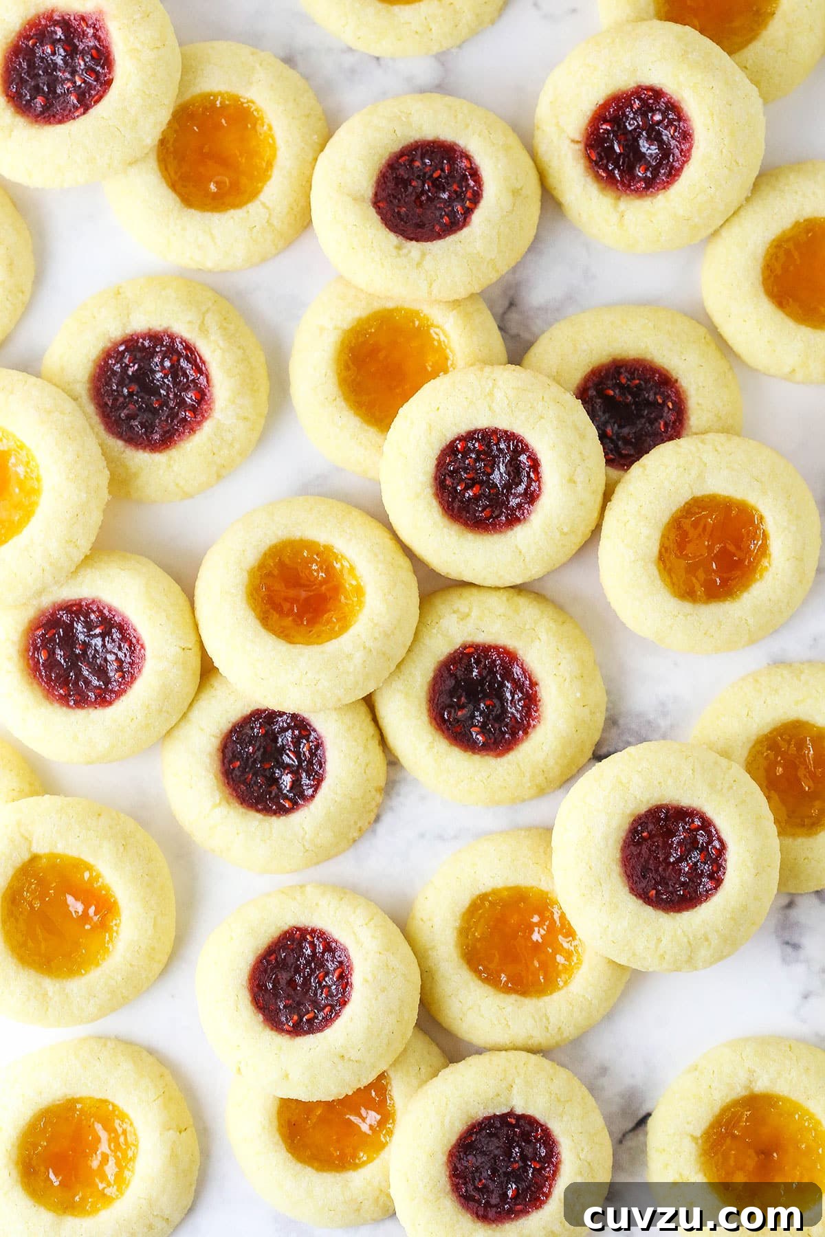 These classic thumbprint cookies are soft and chewy, filled with your favorite jam or preserves. Perfect for Christmas and easy to make! Overhead view of jam thumbprint cookies on a countertop.