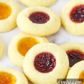 Close up of jam thumbprint cookies on a countertop.