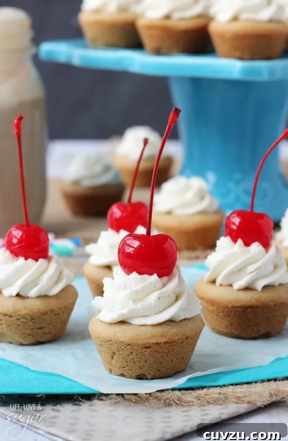 Old-Fashioned Root Beer Float Bites 2 Close-up of three Root Beer Float Cookie Cups, showing the soft cookie base, fluffy whipped cream, and a vibrant cherry on top.