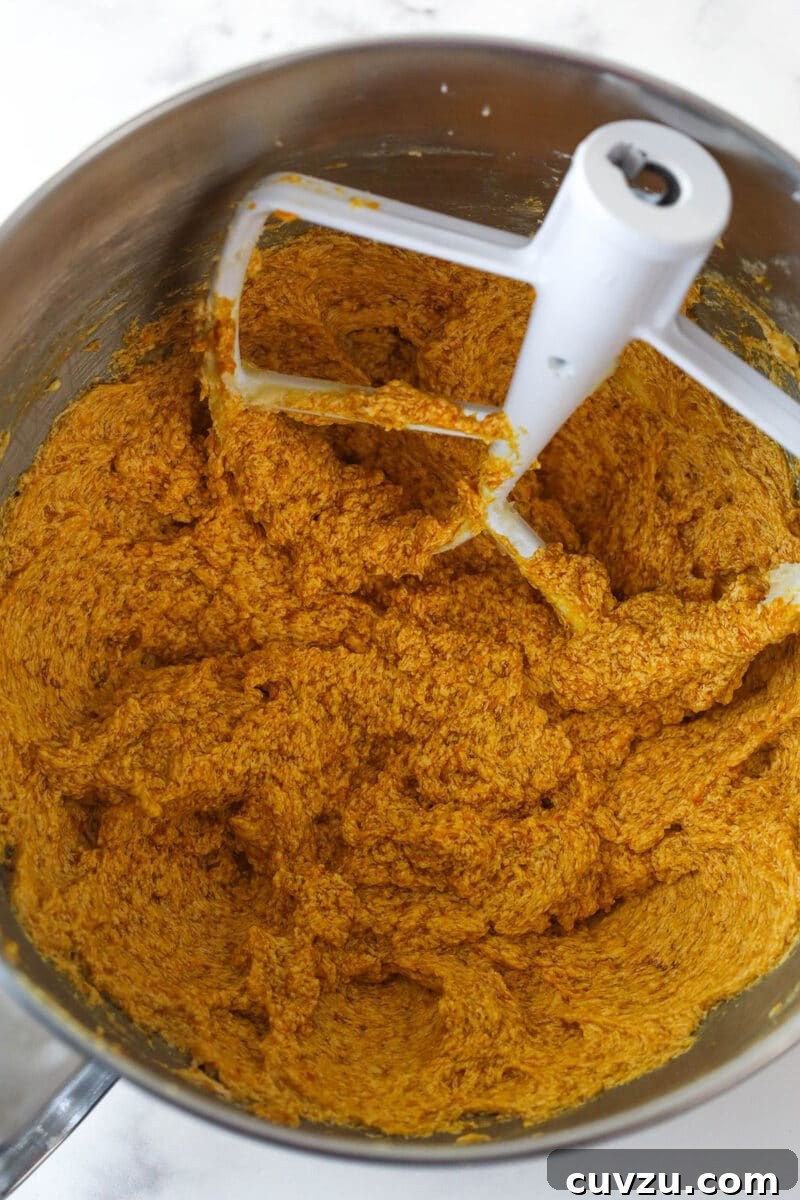 Pillowy Pumpkin Delights 6 Adding pumpkin puree to creamed butter and sugar mixture.