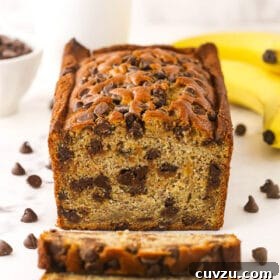 Decadent Chocolate Chip Banana Loaf 2 A loaf of banana bread with two freshly cut slices in front of it