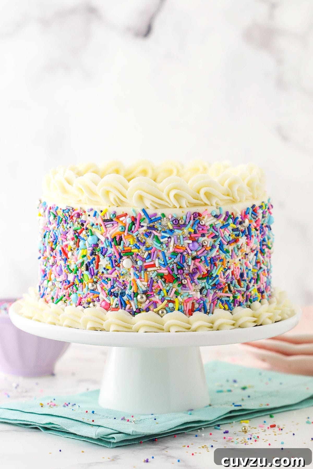 Classic 6-inch Vanilla Delight 2 6 inch vanilla cake covered in sprinkles on blue napkin