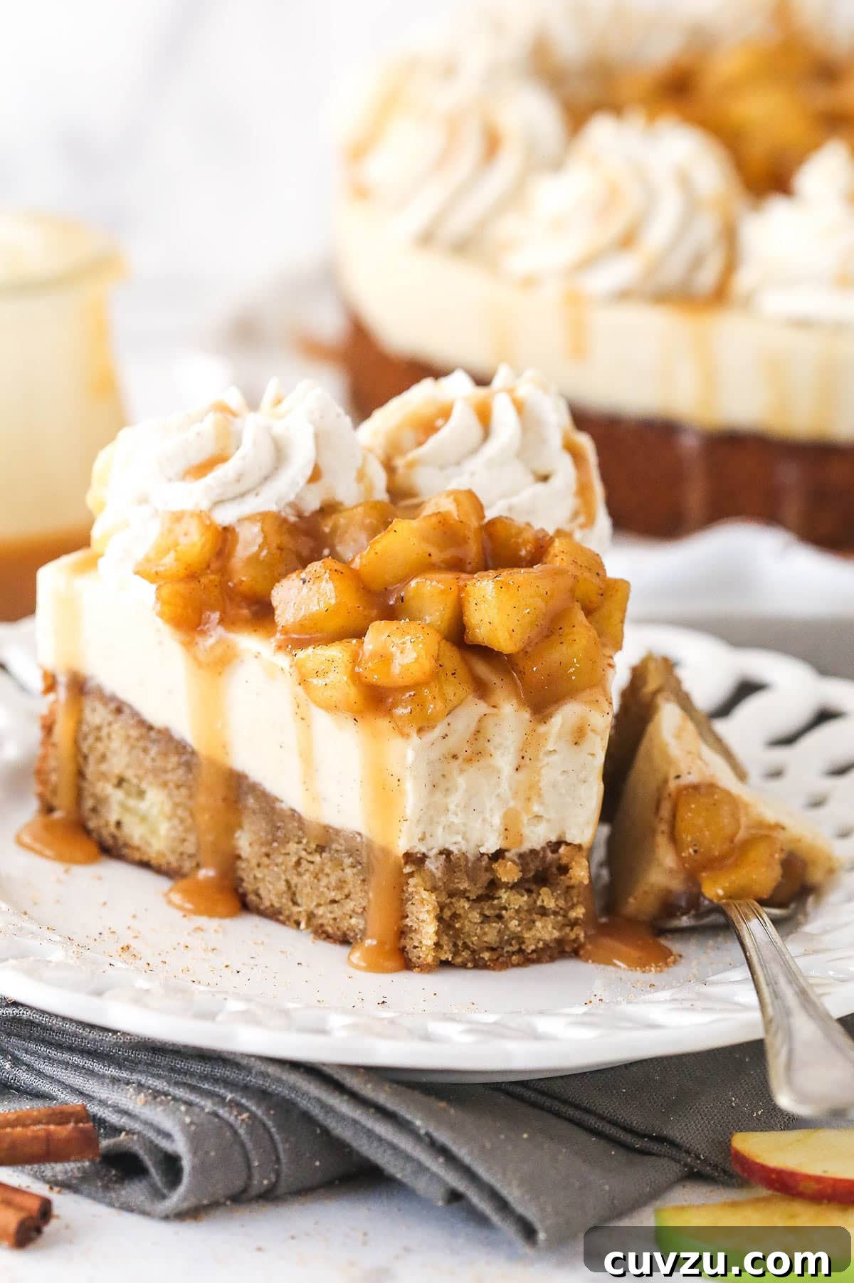 Decadent Caramel Apple Blondie Cheesecake 13 A slice of Caramel Apple Blondie Cheesecake on a small white plate, with a bite playfully removed, highlighting its deliciousness.