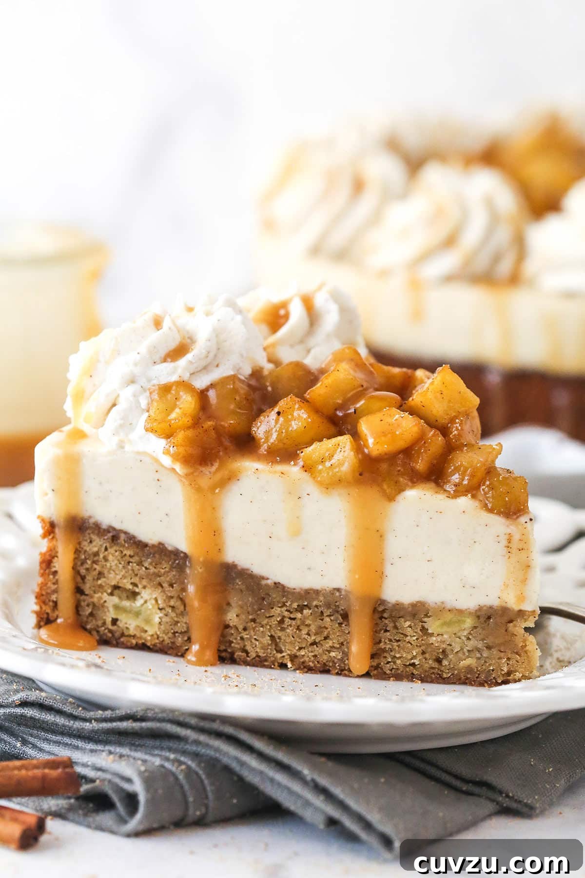 Decadent Caramel Apple Blondie Cheesecake 4 Side view of a perfectly sliced Caramel Apple Blondie Cheesecake on a small white plate, showing the distinct layers.