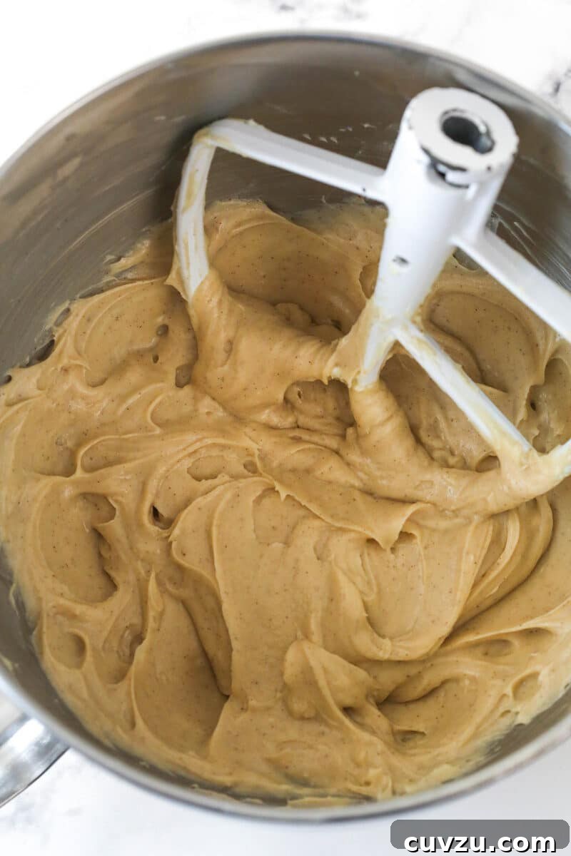 Decadent Caramel Apple Blondie Cheesecake 9 A mixing bowl filled with the cheesecake base, now mixed with caramel sauce and spices, ready for the next step.