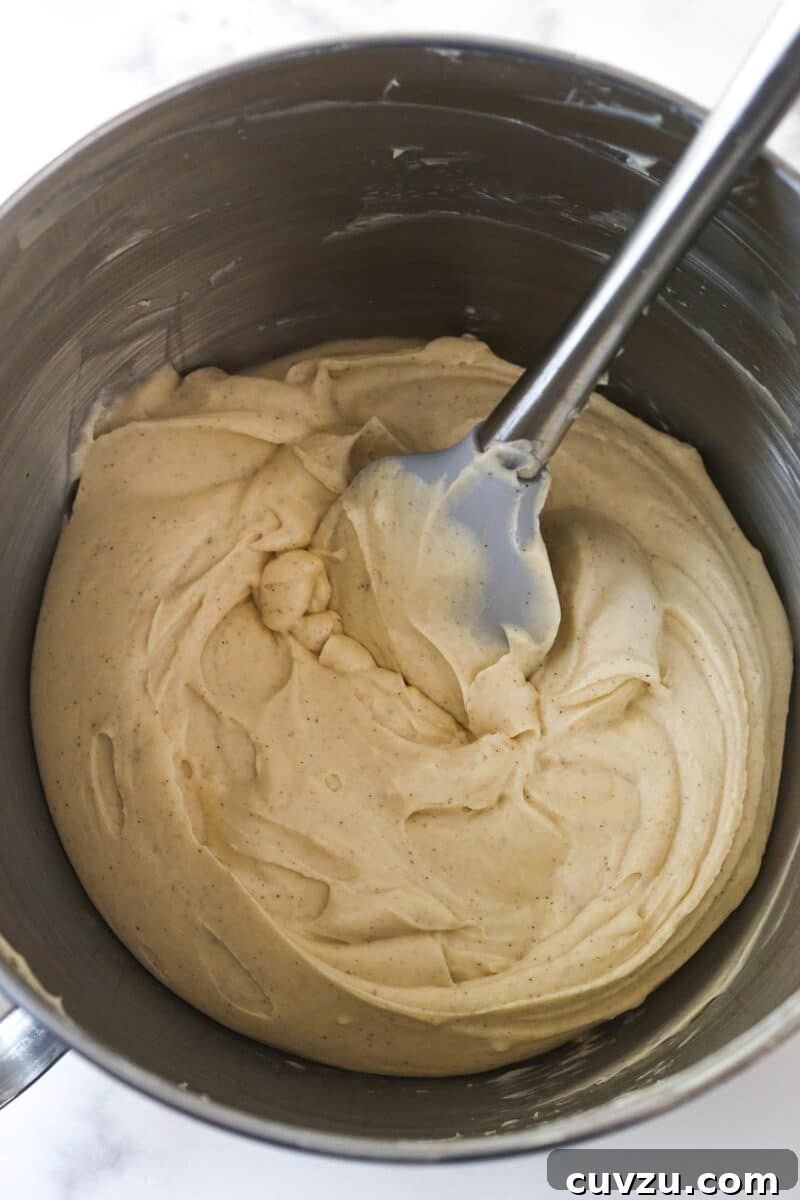Decadent Caramel Apple Blondie Cheesecake 10 A metal mixing bowl showcasing the light and airy apple cheesecake filling after the whipped cream has been folded in.