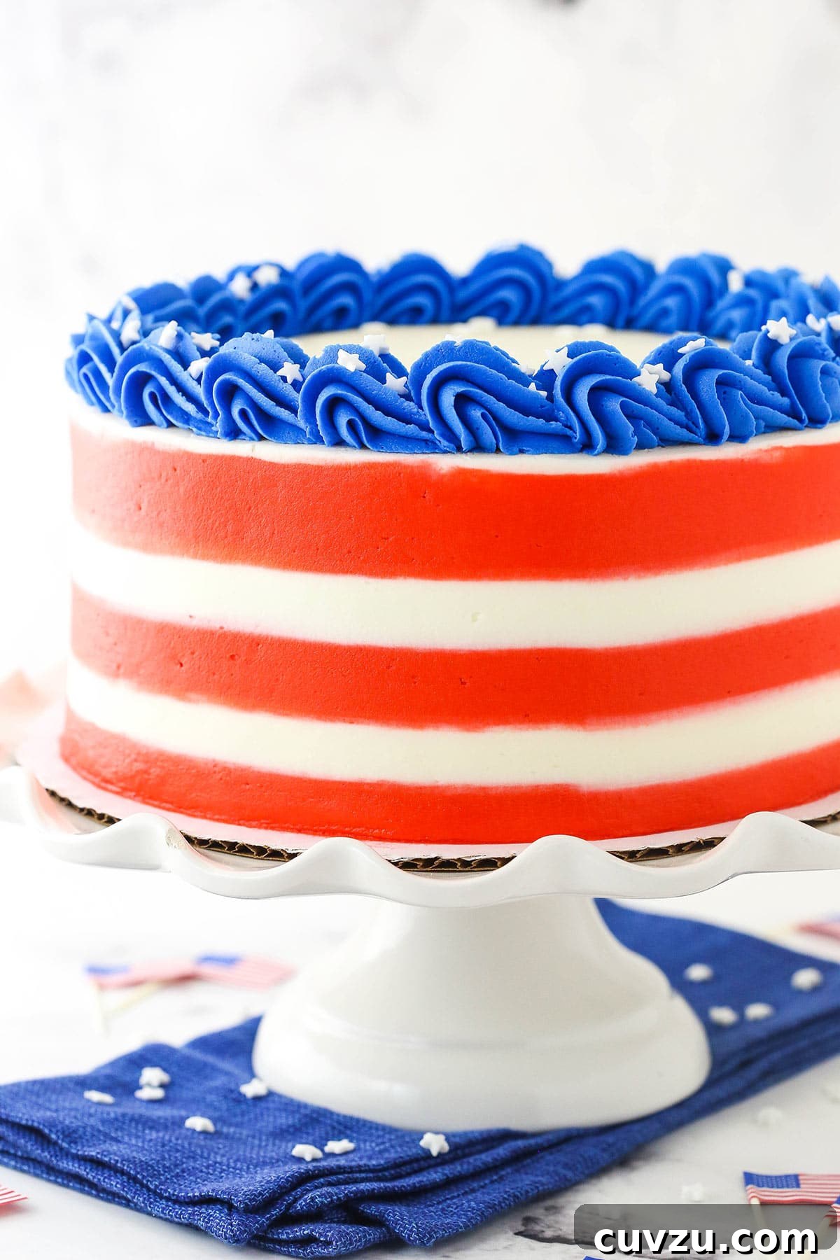 Fourth of July Swirl Cake 3 An America-themed marble cake on a plastic cake stand on top of a blue kitchen towel