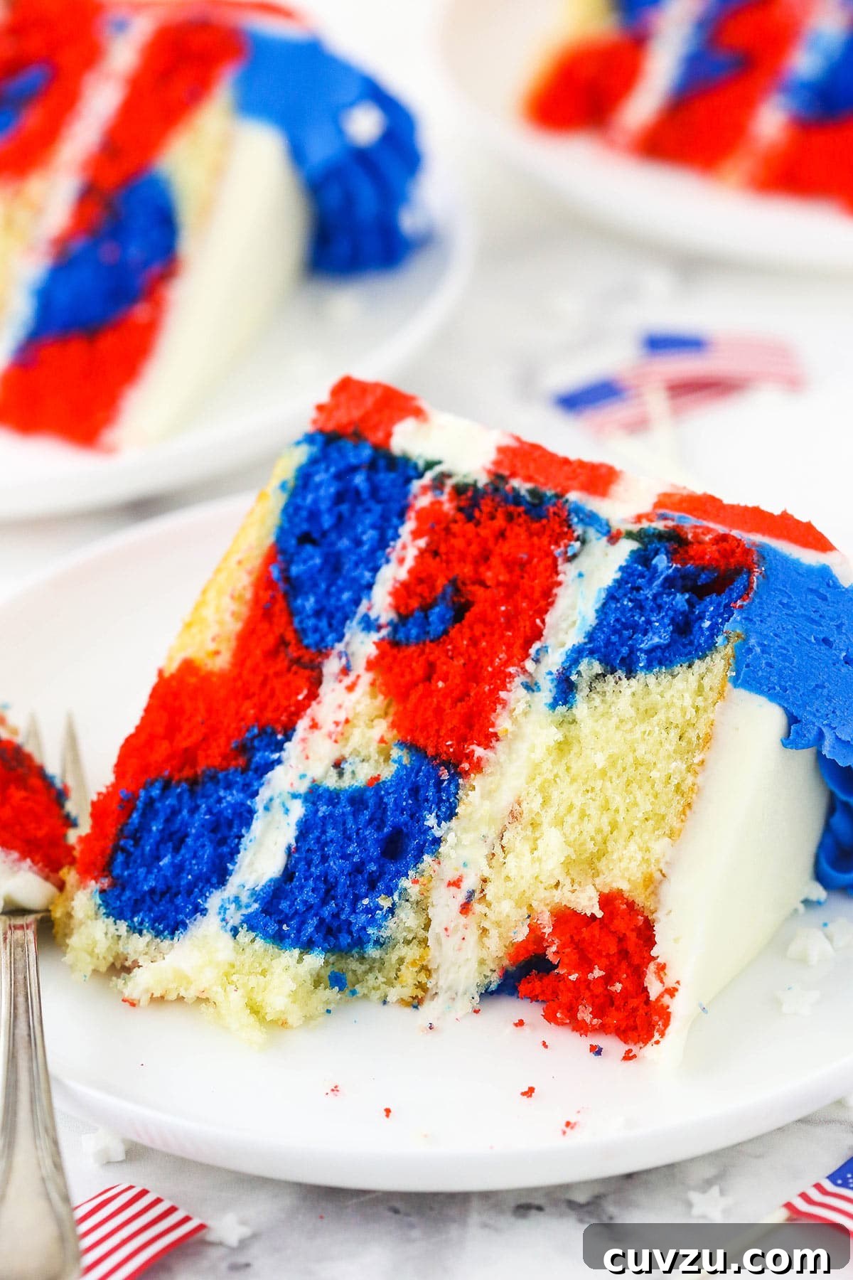Fourth of July Swirl Cake 4 A slice of red, white and blue cake on a plate with a few bites taken out