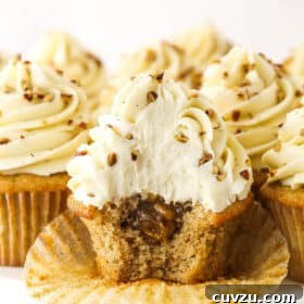 An unwrapped pecan pie cupcake with a bite taken out of it to reveal the gooey filling