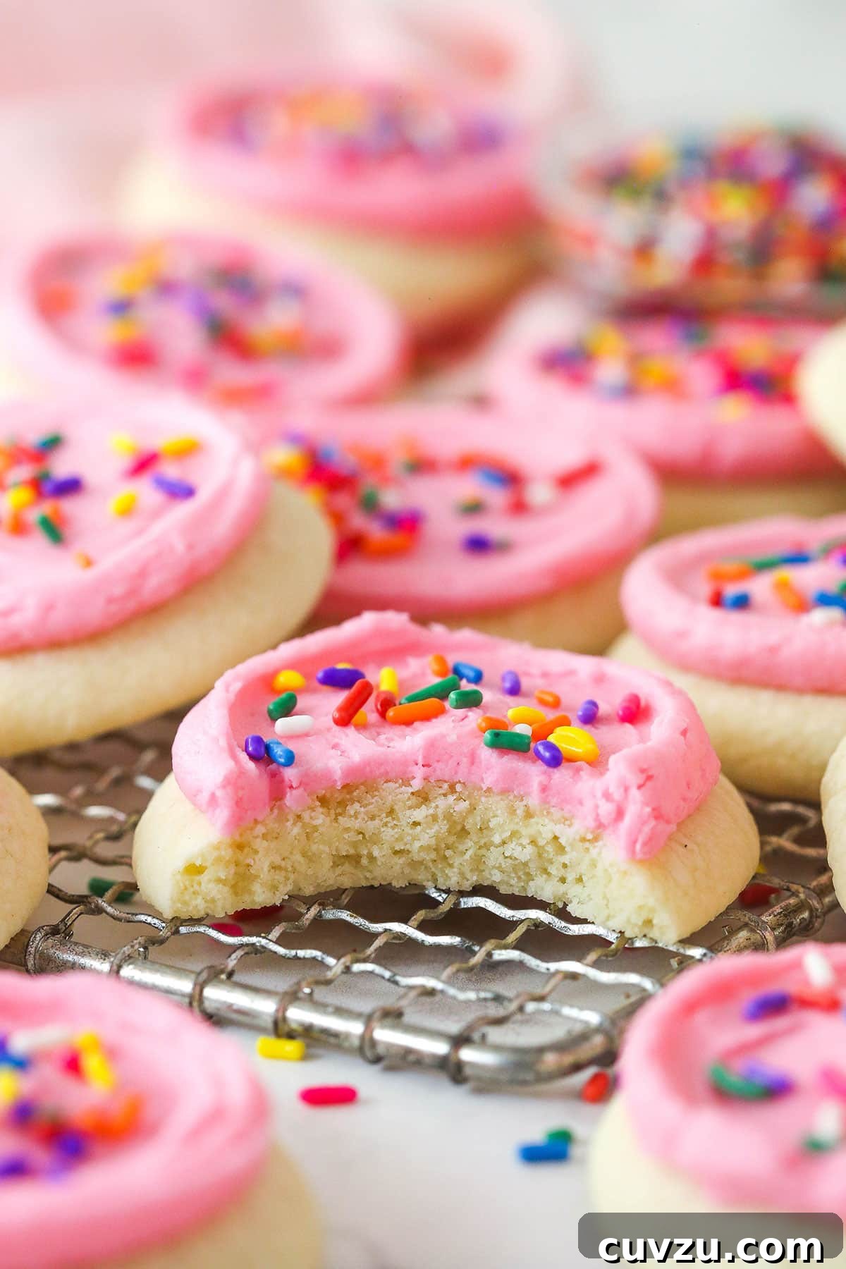 Copycat Lofthouse Cookies Copycat Lofthouse cookies on a wire rack, one with a bite missing