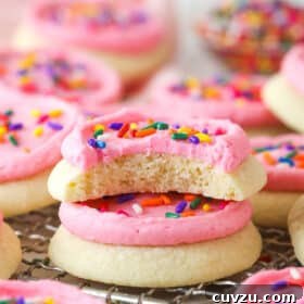 Homemade Lofthouse-Style Soft Sugar Cookies Recipe 3 Two copycat Lofthouse cookies stacked on a wire rack, one with a bite missing