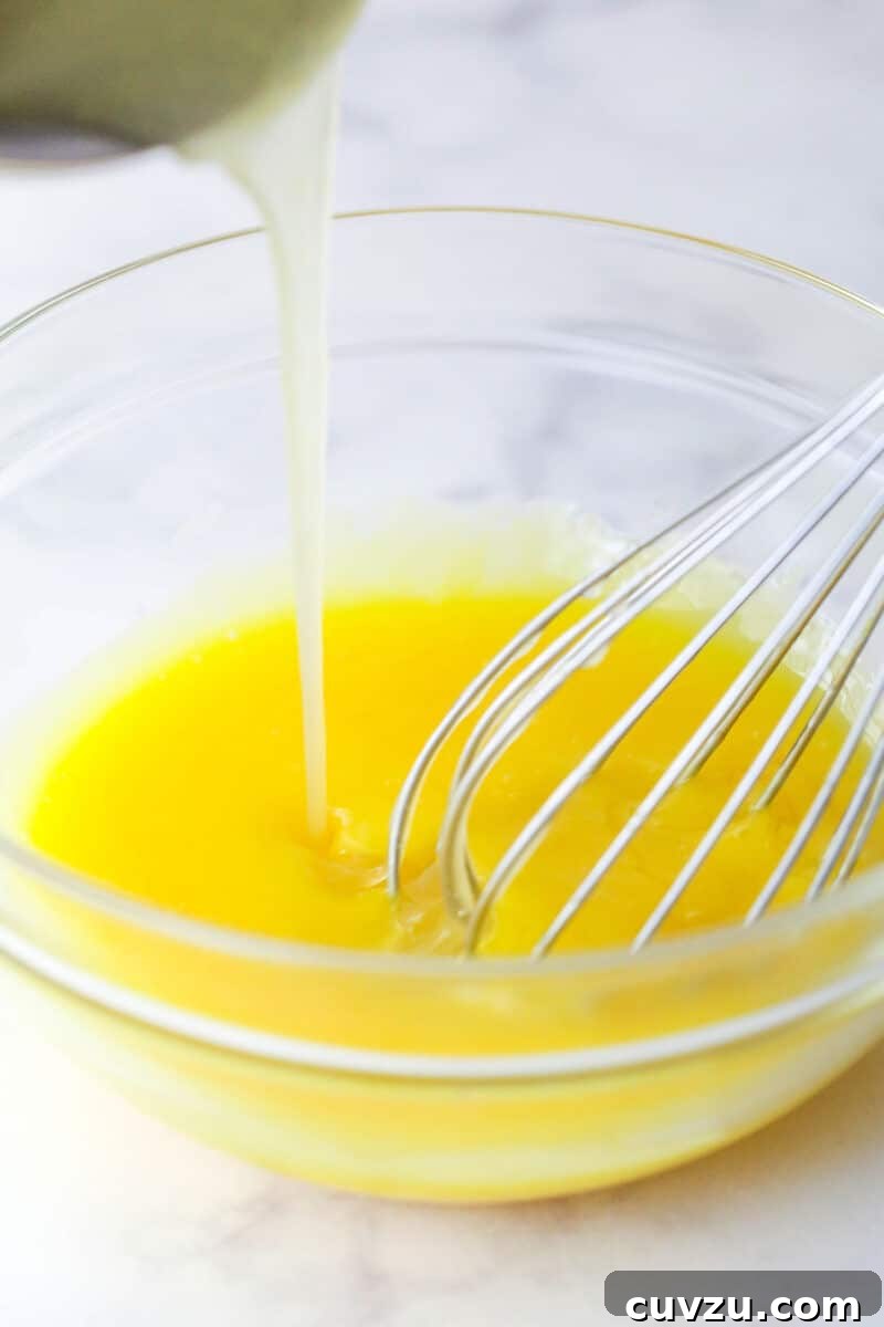 Classic Lemon Meringue Pie Recipe with Flaky Crust and Zesty Filling 6 Tempering egg yolks with warm lemon filling