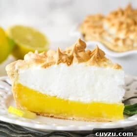 Classic Lemon Meringue Pie Recipe with Flaky Crust and Zesty Filling 11 Side view of a slice of lemon meringue pie on a plate