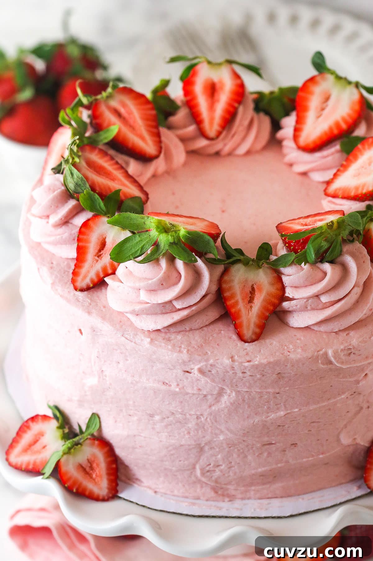 Angled overhead view of a fresh strawberry cake decorated with strawberry slices