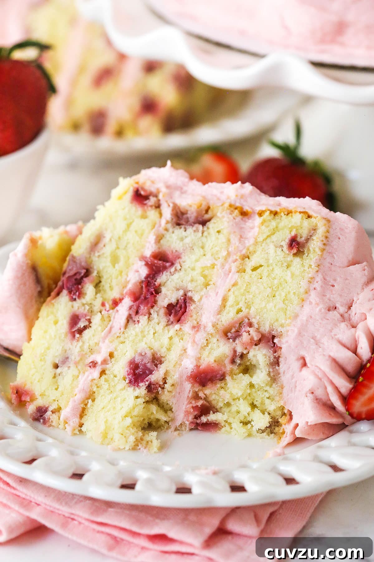 A slice of fresh strawberry cake with a bite missing