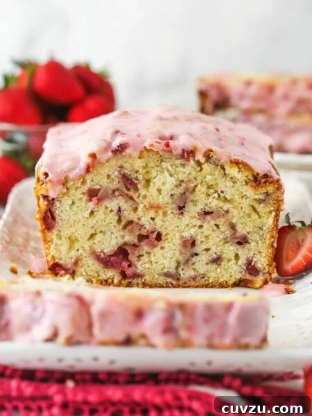 Strawberry bread on a serving platter with a slice cut out of it.