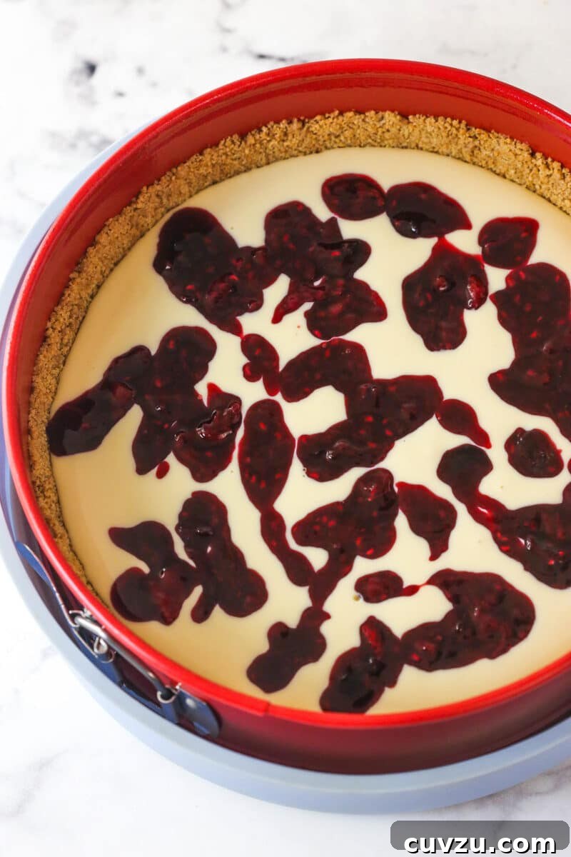 Triple Berry Cheesecake Recipe with Fresh Mixed Berries 14 cheesecake batter in the springform pan with berry filling spooned over top
