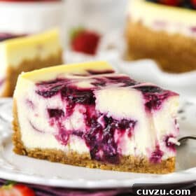 Triple Berry Cheesecake Recipe with Fresh Mixed Berries 19 slice of triple berry cheesecake on white plate