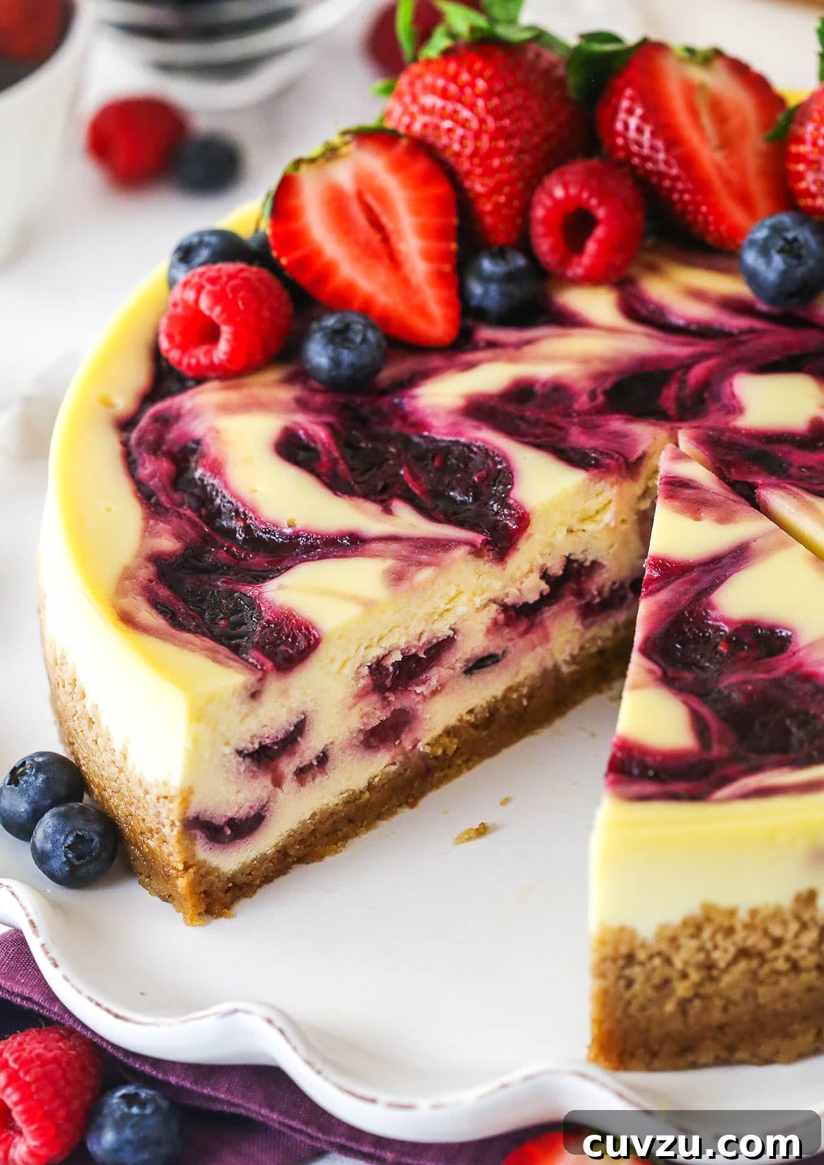 Triple Berry Cheesecake Recipe with Fresh Mixed Berries 5 triple berry cheesecake with a slice removed to see inside